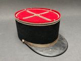 un chapeau noir orné d'un ruban rouge sur le dessus