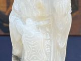 a white figurine of a woman holding a baby
