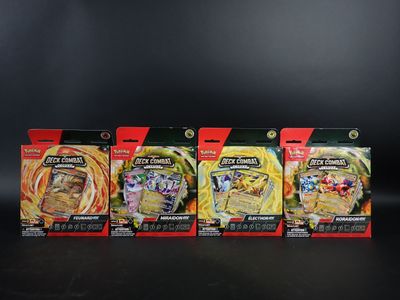 Quatre types différents de jouets Pokémon sont alignés sur une surface noire.