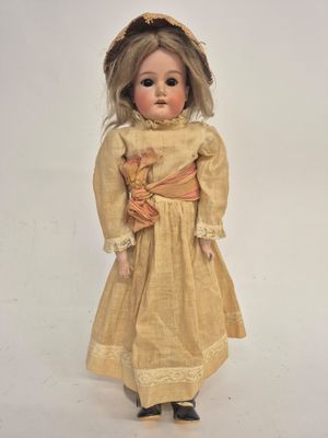 an old fashioned doll with blonde hair and a yellow dress