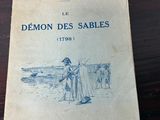un vieux livre posé sur une table, à côté d'une table en bois