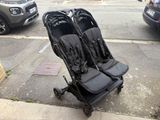 two strollers that are sitting on the side of the street