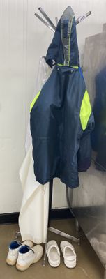 deux paires de chaussures et un manteau suspendus à un porte-vêtements