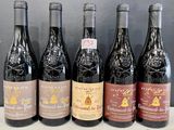 six bottles of red wine are lined up on a counter