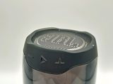 a silver and black speaker sitting on top of a white table
