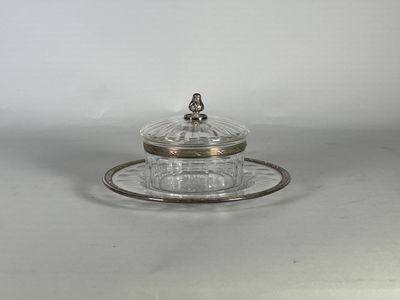 un plateau en argent muni d'un couvercle en verre et d'une soucoupe posée dessus