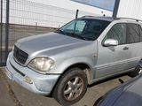 un SUV argenté garé sur un parking à côté d'autres voitures