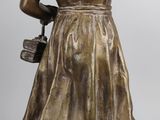 bronze statue of a woman holding a basket and a purse