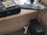 a computer desk with a printer, keyboard, and monitor on it