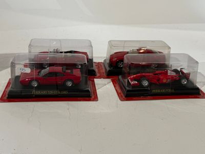 three red cars in a display case on a white surface