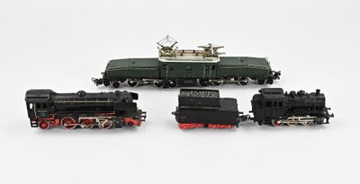 four toy trains sitting on a white surface