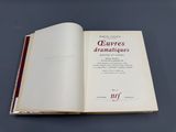 un livre ouvert posé sur une table, sur fond noir
