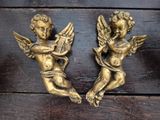 pair of antique brass cheren angels with harps on wooden surface