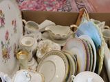 a box full of china plates and bowls on the floor