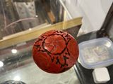 une boule rouge posée sur une table en verre