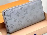 un portefeuille Louis Vuitton dans une boîte posée sur une table, à côté d'une boîte orange