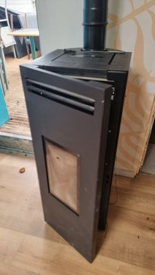 a black stove sitting on a hard wood floor in a room