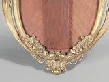 an image of a picture of a gold frame with a pink stone in it