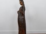a wooden statue of a woman standing on a wooden floor