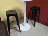 a small table and stool in the corner of the room