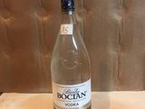 une bouteille de vodka posée sur une table à côté d'une bouteille de vin