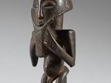 une statue en bronze représentant un homme jouant de la flûte