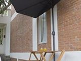 une table et des chaises à l'extérieur d'un bâtiment, surmontées d'un parasol