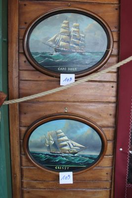deux tableaux représentant des bateaux accrochés au mur d'un magasin