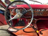 tableau de bord d'une voiture rouge avec un volant et des jauges