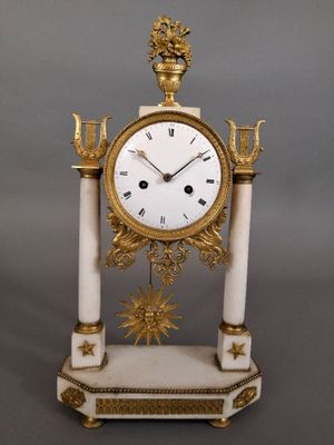 une horloge blanche et or posée sur une table