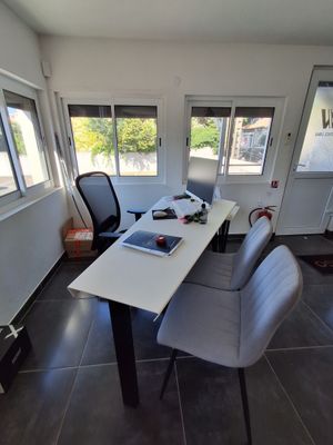 a table with chairs and a laptop on it in a room