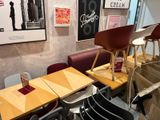 tables and chairs are lined up in a restaurant with posters on the wall