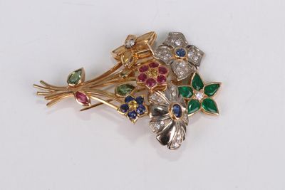 un gros plan d'une broche ornée de fleurs et de feuilles