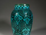 turquoise vase with a black design on the outside of it