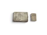 an old silver cigarette case sitting next to a lighter on top of a white surface