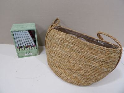 a wicker bag and a box of pencils on a table