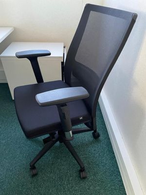 a black office chair in a corner of a room