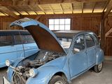 une petite voiture bleue, le capot ouvert, dans un garage