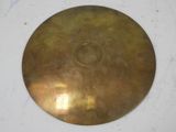 an antique brass plate with a circular hole in the middle