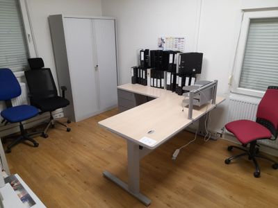 a desk with two chairs and a computer monitor on it