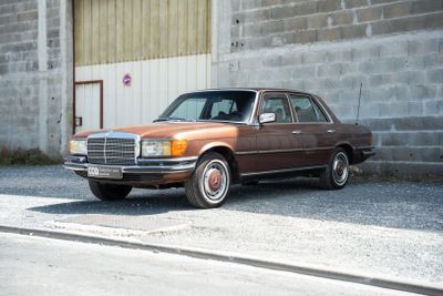 une voiture marron garée devant un immeuble