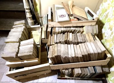 une pile de livres par terre, à côté d'une autre pile de livres