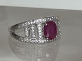 une photo d'une bague sertie d'un rubis et de diamants, posée sur une table