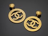 a pair of gold earrings with a circular design