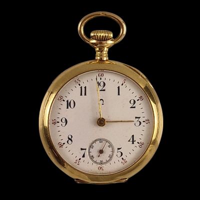 a close up of a gold pocket watch on a black background