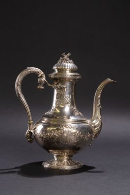 une théière ancienne en argent avec une anse en forme d'oiseau, sur fond noir