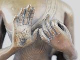 a statue of a person holding their hands together