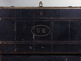 an old black suitcase with a rope on top of it