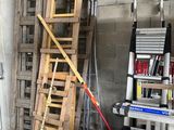 a ladder leaning against a wall next to a pile of tools