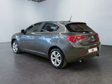 the back end of a grey car in a showroom